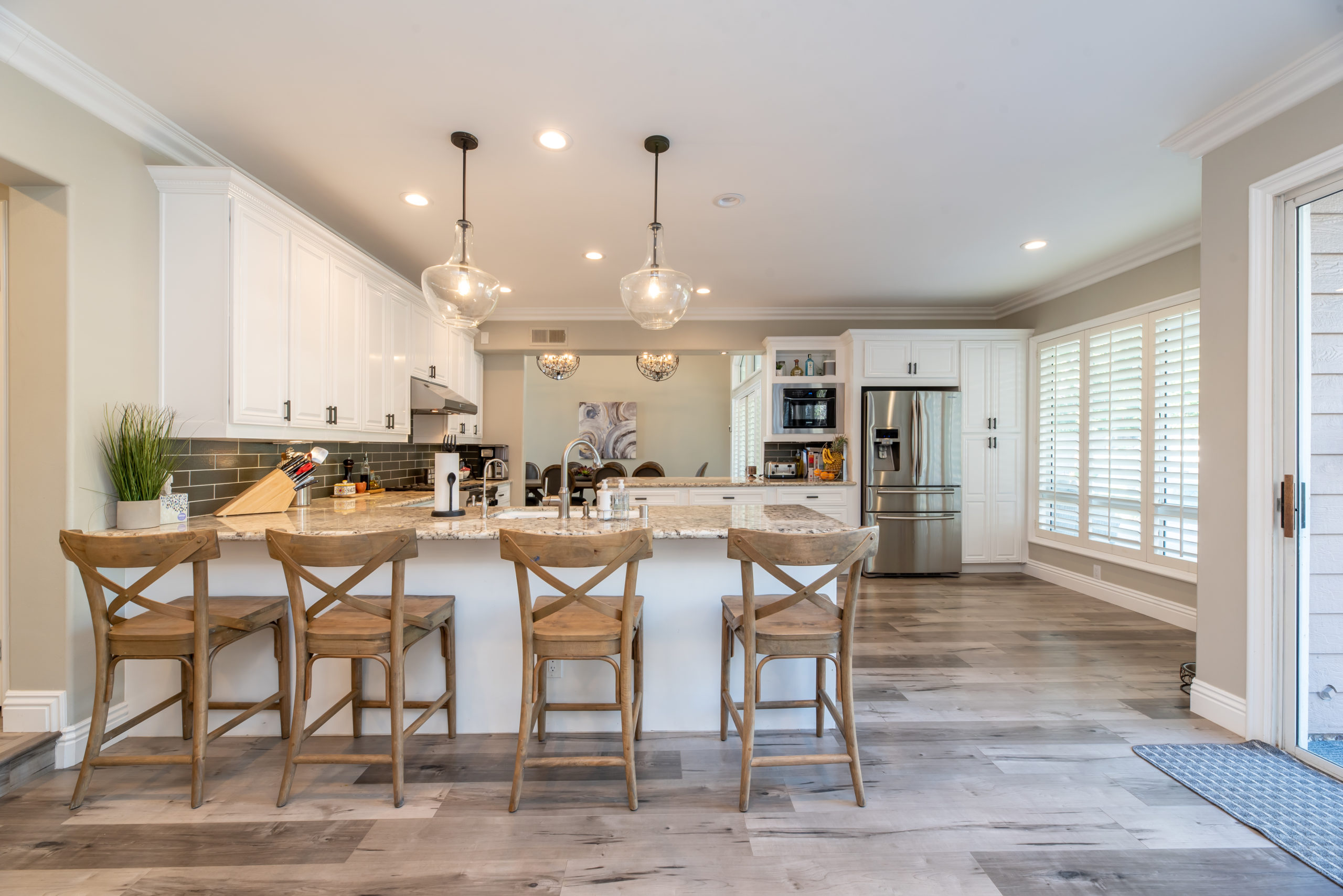 4 chairs by a counter in a kitchen and dining area
